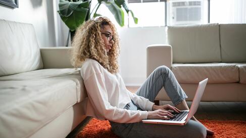 Woman sitting on the floor with a laptop